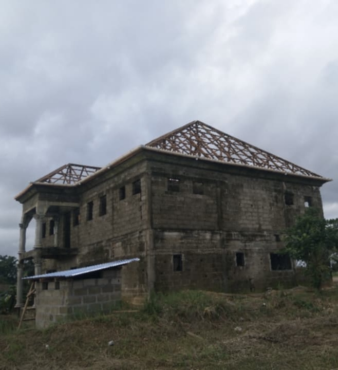 Two-story residence under construction with timber roof trusses