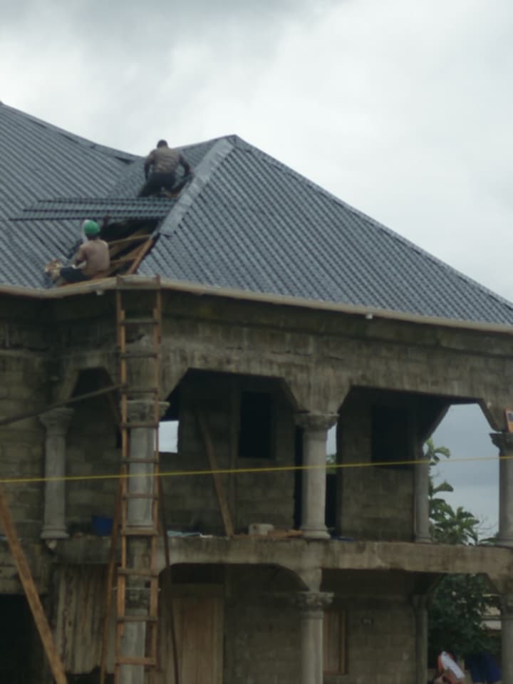 Roof installation in progress on a two-story Liberian villa